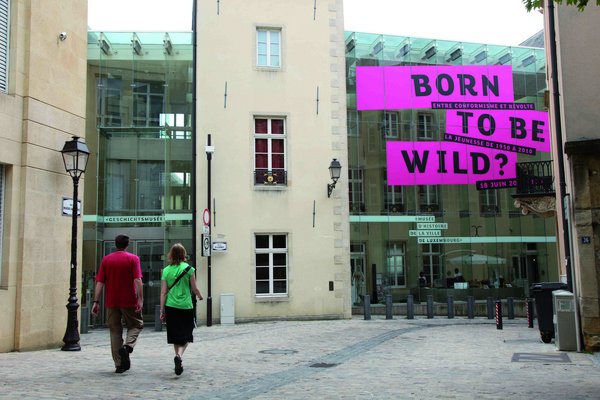 Entrance of the city museum with a big pink "born to be wild" banner on the glass front